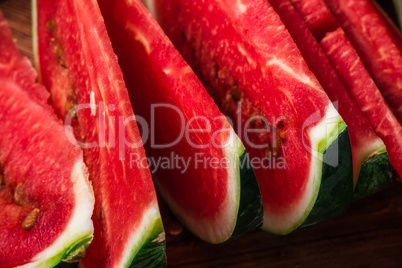 Juicy watermelon slices lying on wooden surface