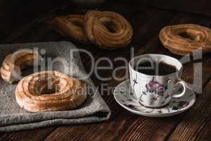 Few round eclairs with cup of coffee