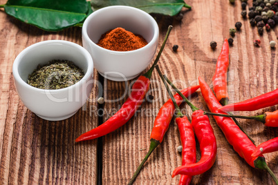 Different spices in bowls and scattered on table