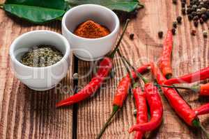 Different spices in bowls and scattered on table