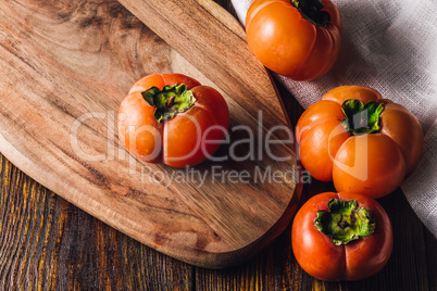 Ripe Persimmons on Cutting Board