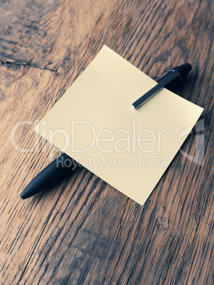 Sticky note with a pen on a table