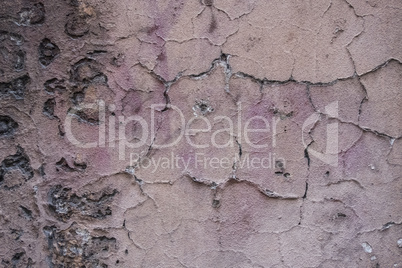 Decayed pink peeling plaster concrete wall.