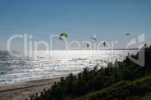 Kitesurfers from the top of a sand dune.