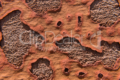 Orange peeling paint on an old concrete wall.