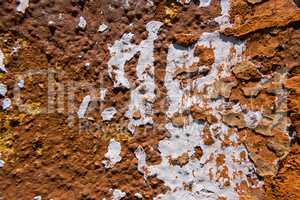 White stain on an old worn concrete orange wall.