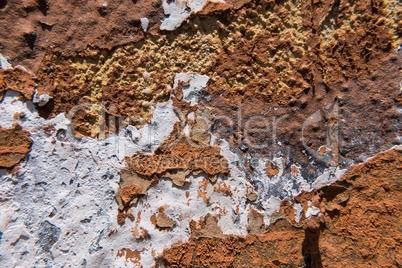 White paint on an old worn concrete orange wall.