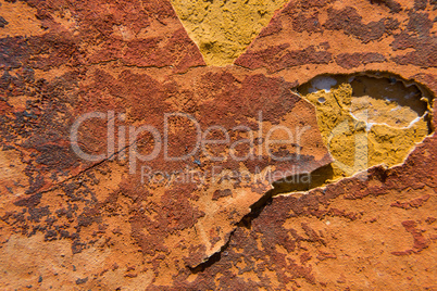 Cracked orange paint on a yellow concrete wall texture.