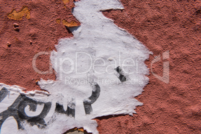 White piece of paper on a red concrete wall.
