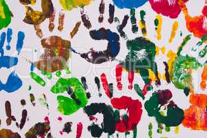 Detail of colorful handprints on a wall.