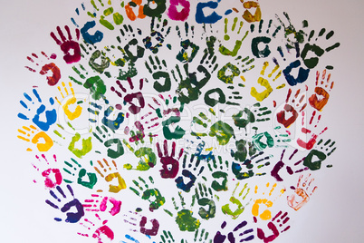 Circle made of colorful handprints on a wall.
