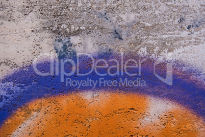 Orange and purple paint on a concrete wall.