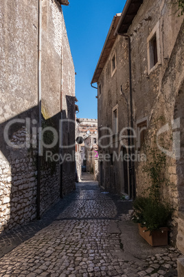 Medieval alley with a castle tower on the background.