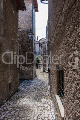 Low window with metal bars on a medieval town alley.