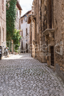 Scooter and bicycle parked on a medieval town.