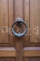 Antique door knocker on a wooden door.