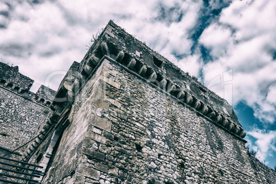 Ancient worn stone castle detail with clouds and blue sky backgr