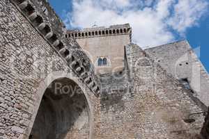 Medieval stone castle facade with arches and blue sky background