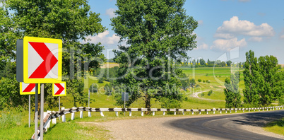 winding road with steep turns in the hilly terrain. Green field