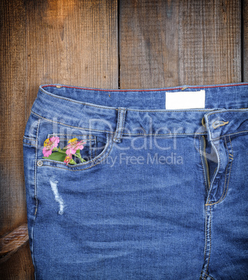 blue jeans with a bouquet of flowers in a front pocket