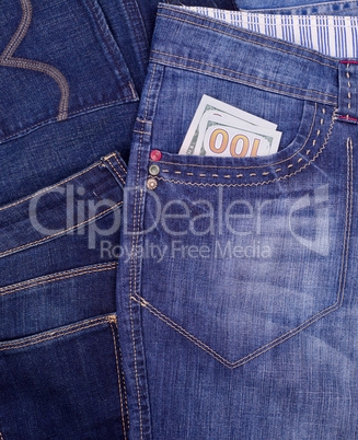 paper bill hundred US dollars in the front pocket of blue jeans,