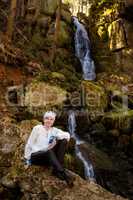Woman enjoys the leisure at the waterfall