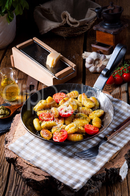 gnocchi baked with green pesto, cherry tomatoes and parmesan