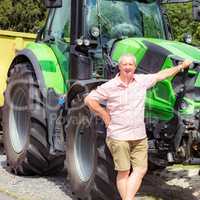 Farmer stands beside his tractor