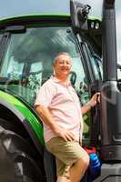 Farmer stands beside his tractor