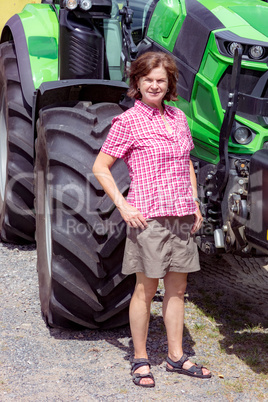 Farmer is standing next to her tractor