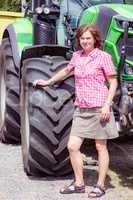 Farmer is standing next to her tractor