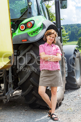 Farmer is standing next to her tractor