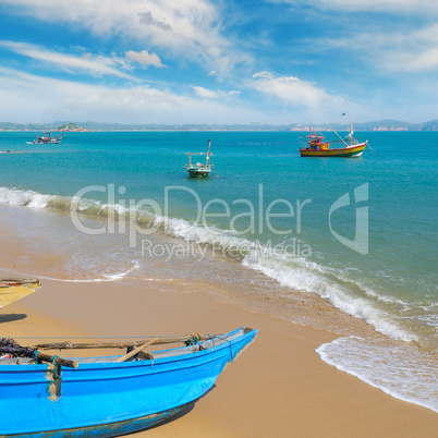 Fishing boat on the sandy shore against a background the ocean a