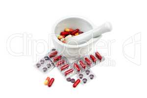 Assortment of medicinal tablets and mortar with pestle isolated