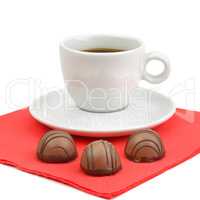 A cup of coffee and chocolate candies isolated on white backgrou
