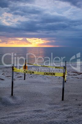 Sunset behind a fenced-off turtle nest on Clam Pass Beach