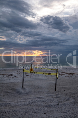 Sunset behind a fenced-off turtle nest on Clam Pass Beach