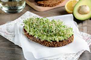 Sandwich with avocado and alfalfa sprouts