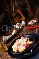 gnocchi baked with green pesto, cherry tomatoes and parmesan