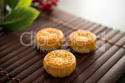 Moon cakes on bamboo mat low light with copyspace