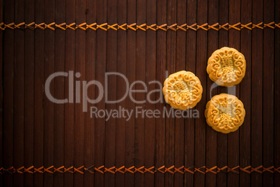 Moon cakes on bamboo mat low light with copy space