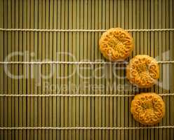 Mooncakes on bamboo mat dark light with copy space