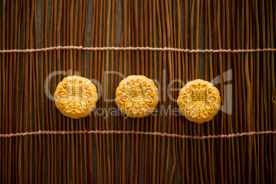 Moon cakes on bamboo mat with copy space dark light