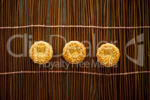 Moon cakes on bamboo mat with copy space dark light