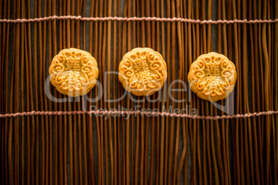 Moon cakes on bamboo mat with copy space low light