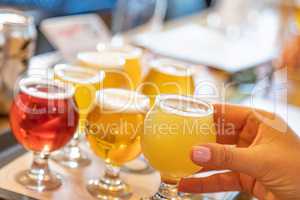 Female Hand Picking a Glass of Micro Brew Beer From Variety
