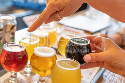 Female Hand Picking a Glass of Micro Brew Beer From Variety