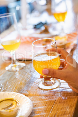 Female Hand Holding Glass of Micro Brew Beer At Bar