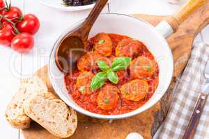 Baked mini meatballs in tomato sauce with basil