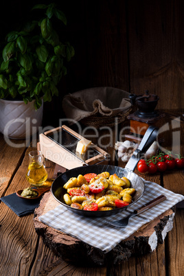 gnocchi baked with green pesto, cherry tomatoes and parmesan